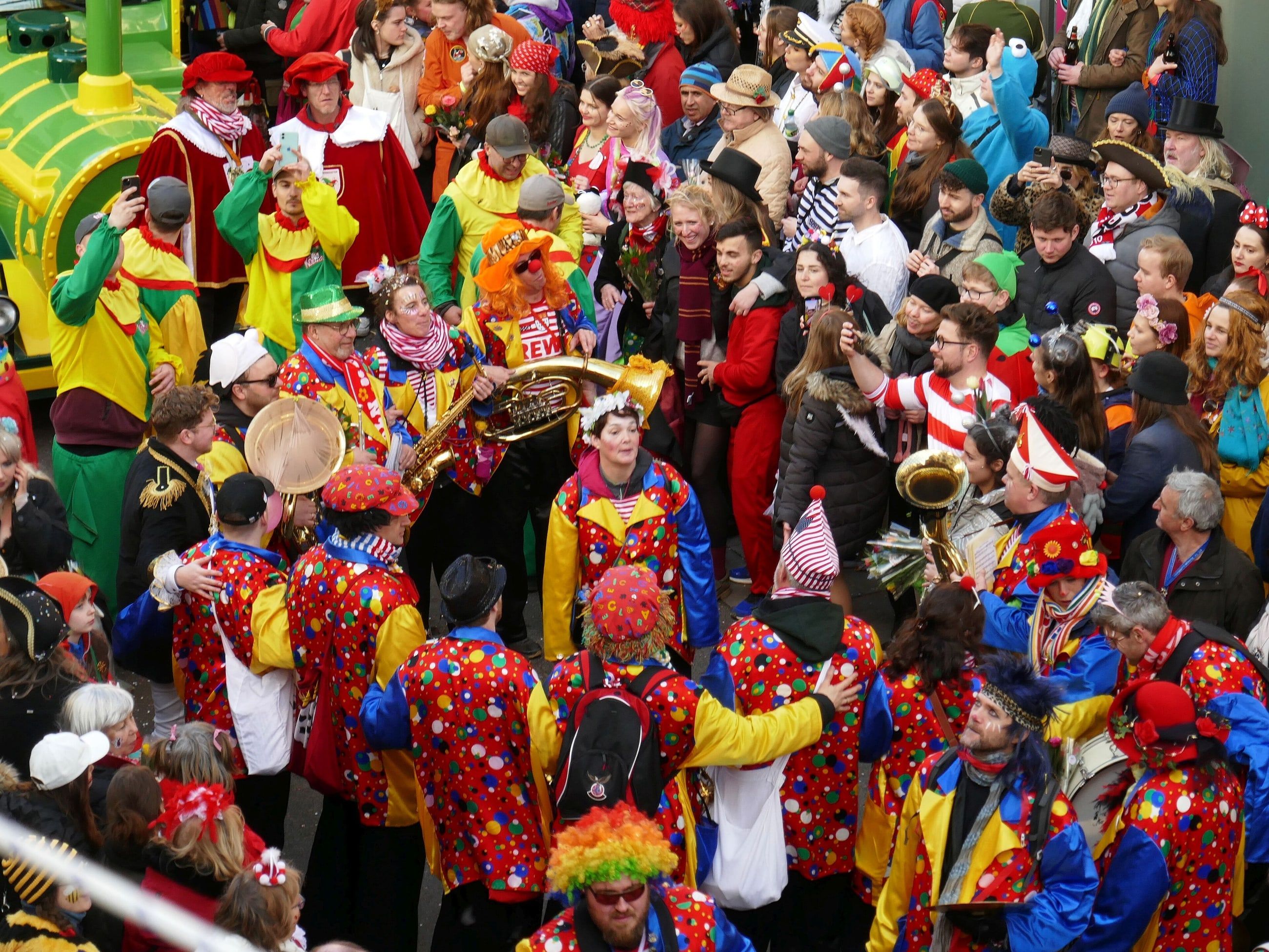Dicht gedrängte Fußgruppe in bunten Kostümen beim Kölner Rosenmontagszug, von oben gesehen.