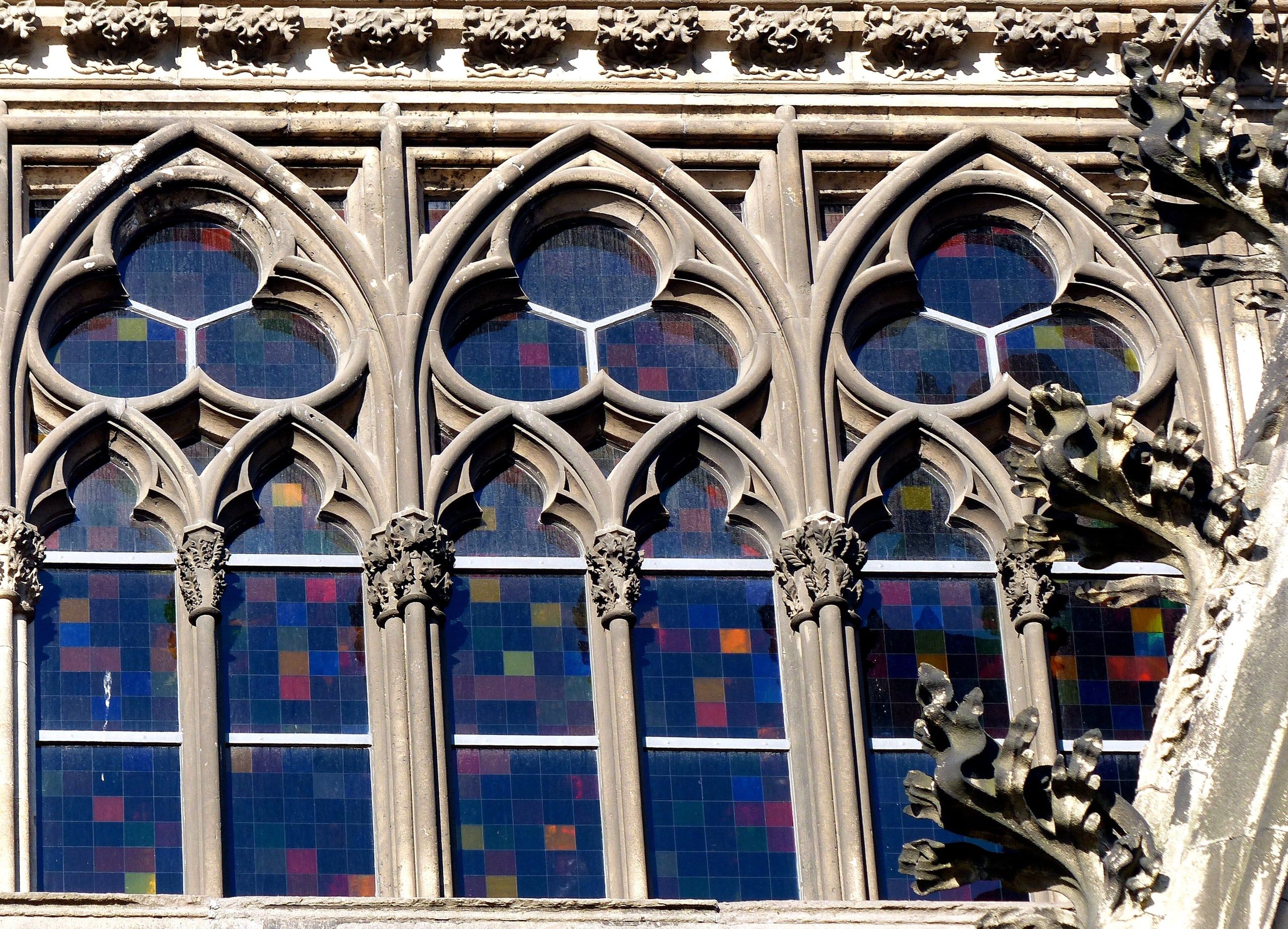 Außenansicht des Richter-Fensters im Kölner Dom mit farbigen Glasquadraten hinter dem Maßwerk.